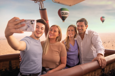 four adults taking a selfie during a hot air balloon trip in dubai